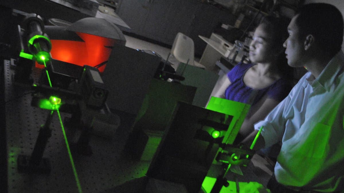A laser beam experiment on an optical bench in a photonics laboratory