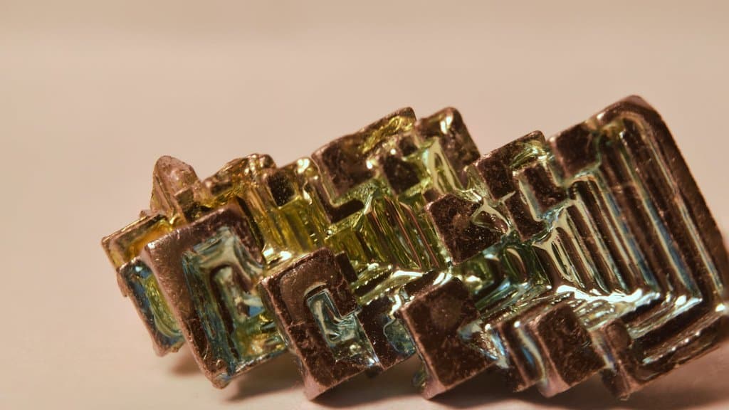 Iridescent stair-stepped crystal of elemental bismuth showing rainbow oxide colours