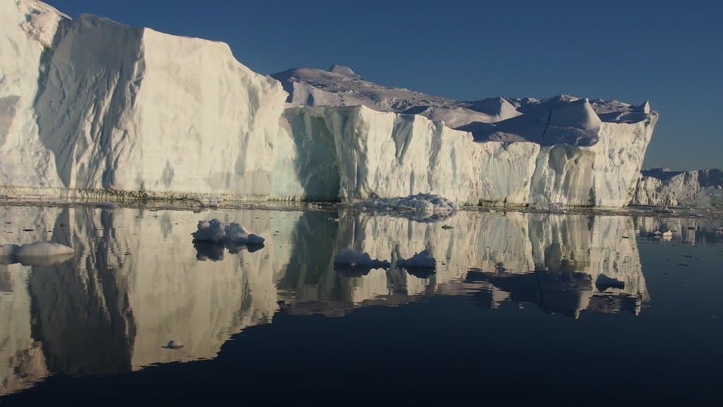 An iceberg calving off Jakobshavn Glacier (Sermeq Kujalleq), Greenland