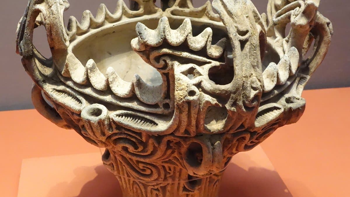 An elaborately decorated earthenware vessel from Japan's Jomon period with flame-like rim ornamentation.