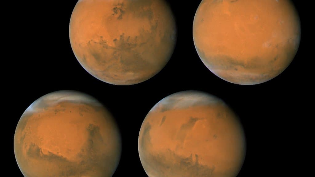 The planet Mars imaged by the Hubble Space Telescope, showing rusty surface features and a polar cap.