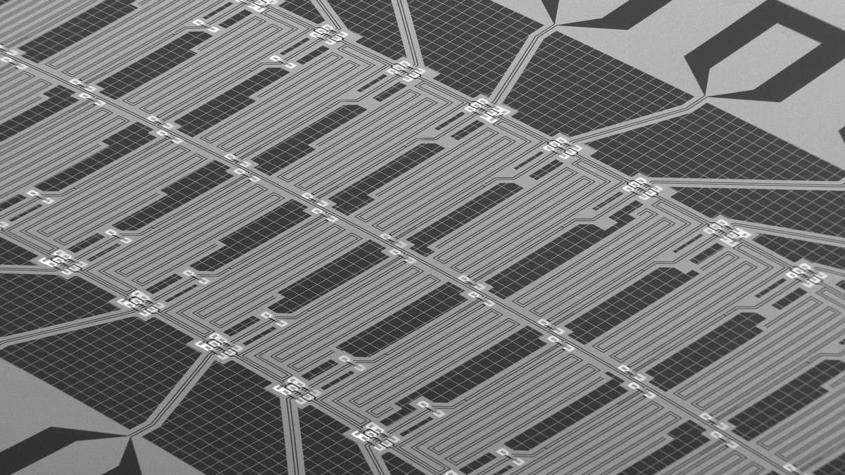 Close-up of a superconducting chip patterned with metal circuit structures on a silicon substrate