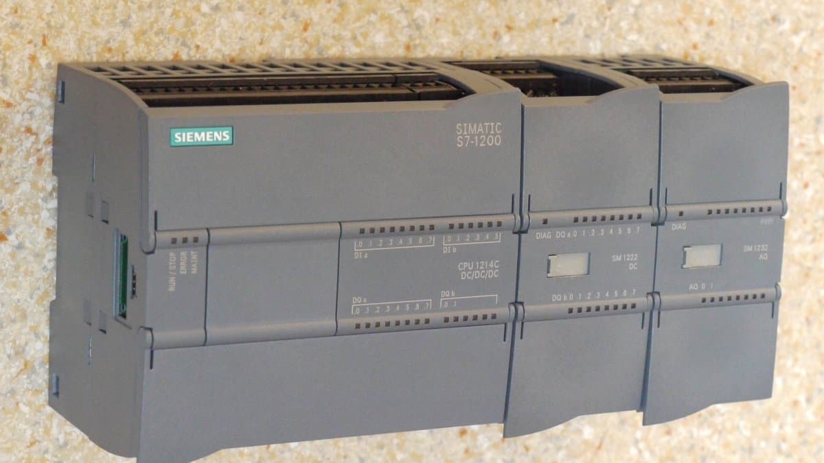 A Siemens Simatic S7-1200 programmable logic controller mounted on a DIN rail with wiring terminals and status LEDs