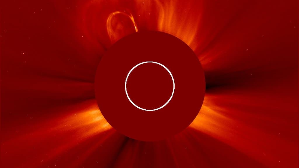 Two coronal mass ejections billow away from the Sun as bright clouds of plasma beyond the dark occulting disc of a coronagraph.