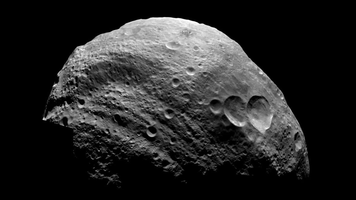 Close view of the asteroid Vesta from NASA's Dawn spacecraft: a lumpy grey world covered in overlapping craters, lit from the left against black space.
