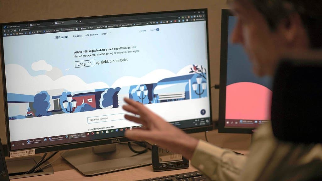 The Altinn front page displayed on a screen while a man points at it.
