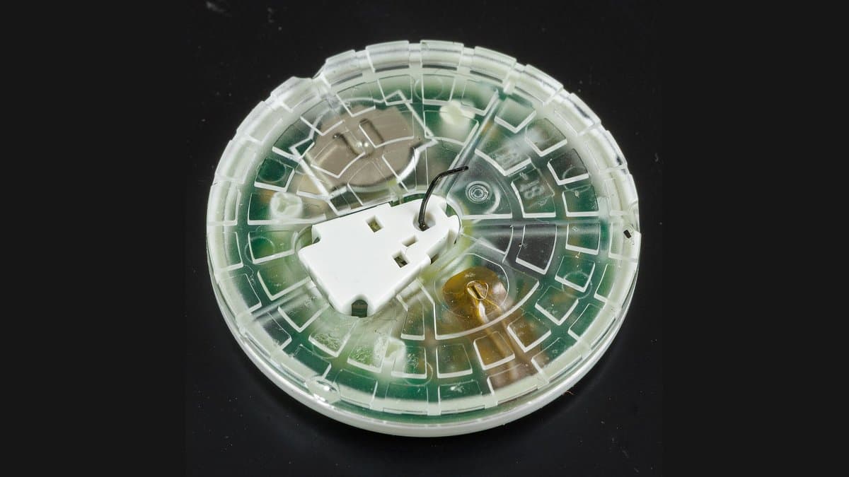 A circular white Abbott FreeStyle Libre 2 glucose sensor photographed against a plain background.