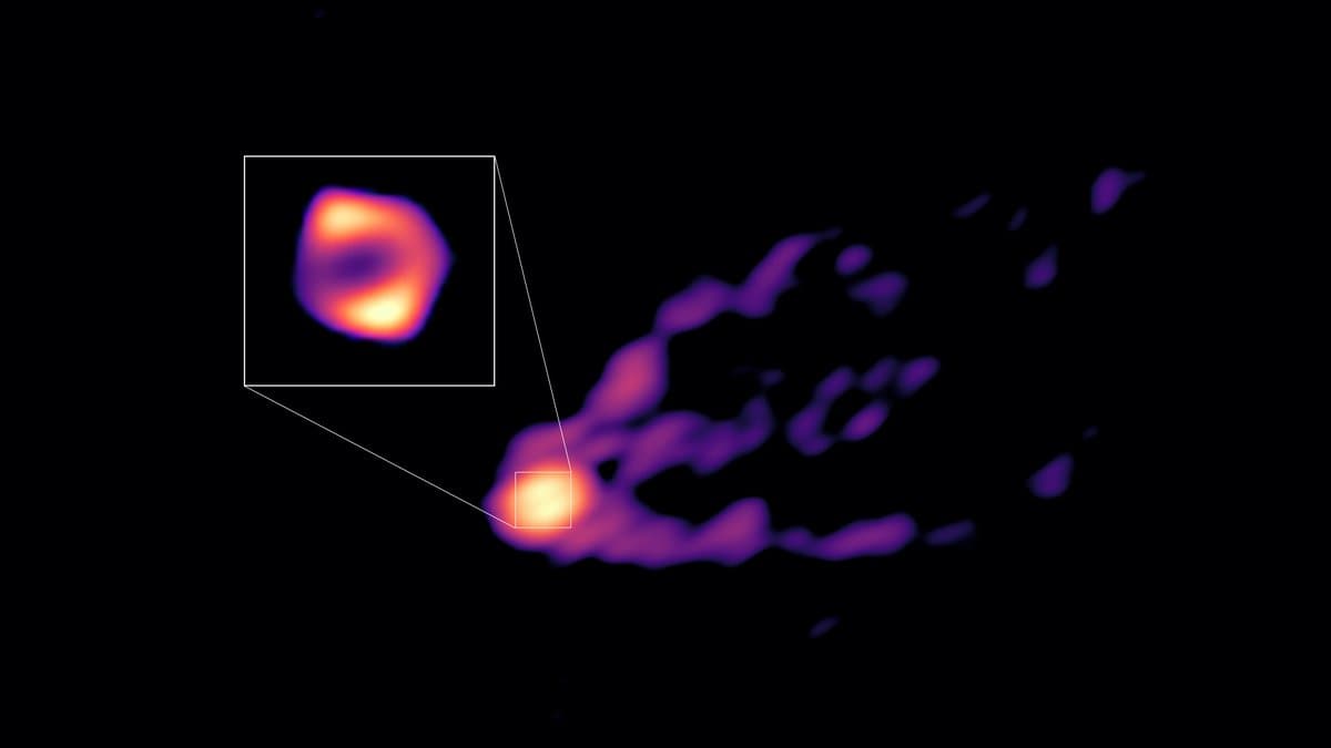 A radio image of a supermassive black hole: a bright knotted plasma jet streaming out to the right, with an inset showing the glowing ring around the black hole itself.