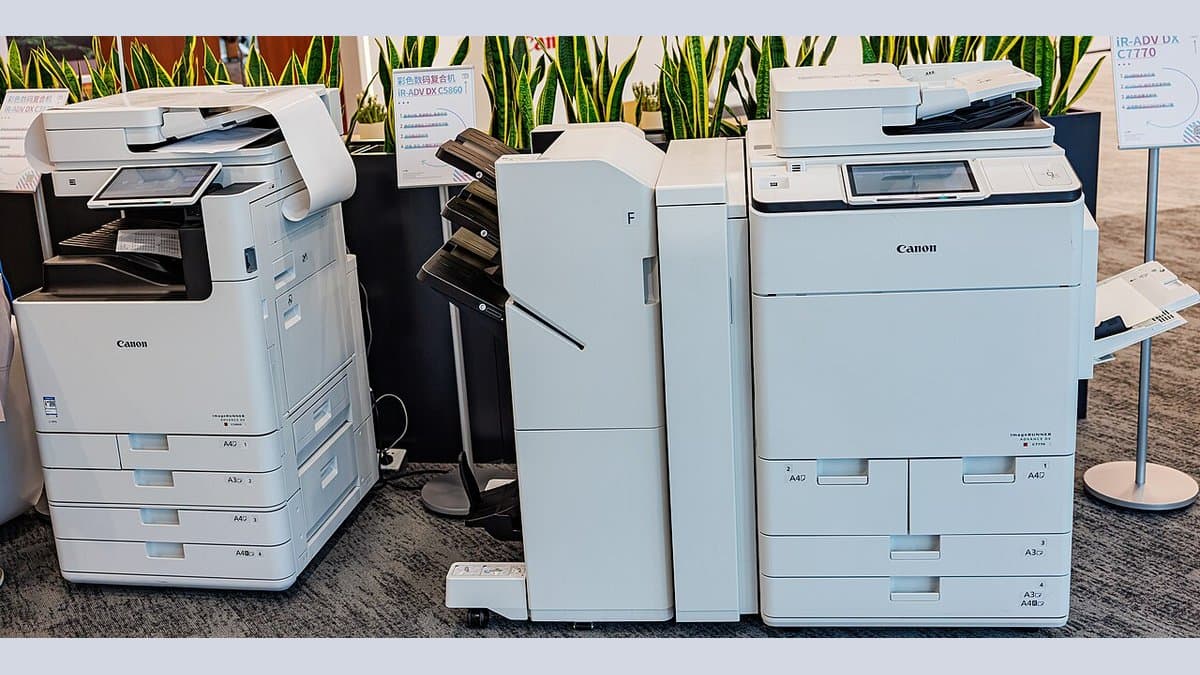 Two large office multifunction laser printers standing side by side