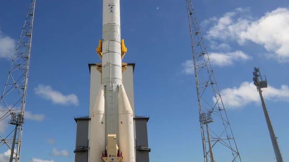 An Ariane 6 launch vehicle standing on its launch pad at Europe's Spaceport with the mobile gantry rolled back