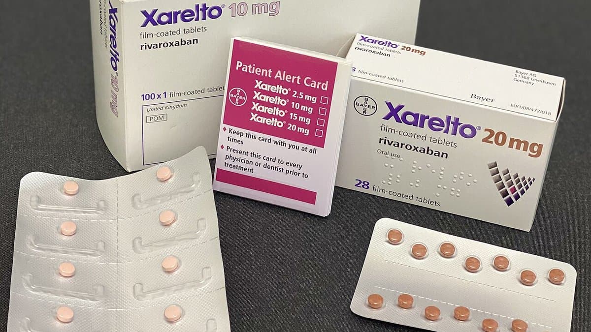 Cartons and blister packs of rivaroxaban film-coated tablets, sold as Xarelto, laid out on a grey surface.
