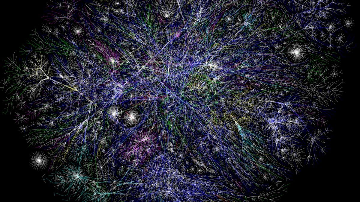 A dense radial map of a computer network: thousands of bright nodes joined by fine coloured lines fanning out across a black field.