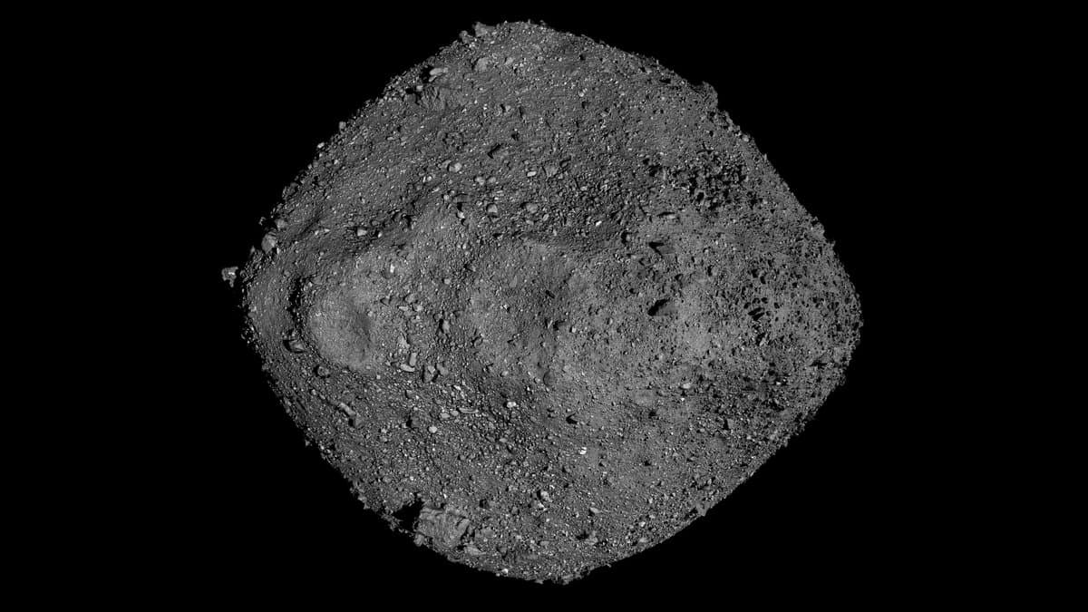 The asteroid Bennu, a grey spinning-top-shaped body covered in boulders and loose rubble, photographed against black space.