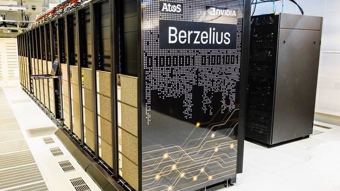 A long row of black supercomputer cabinets in a machine hall at Linkoping University; the end panel carries the name Berzelius.