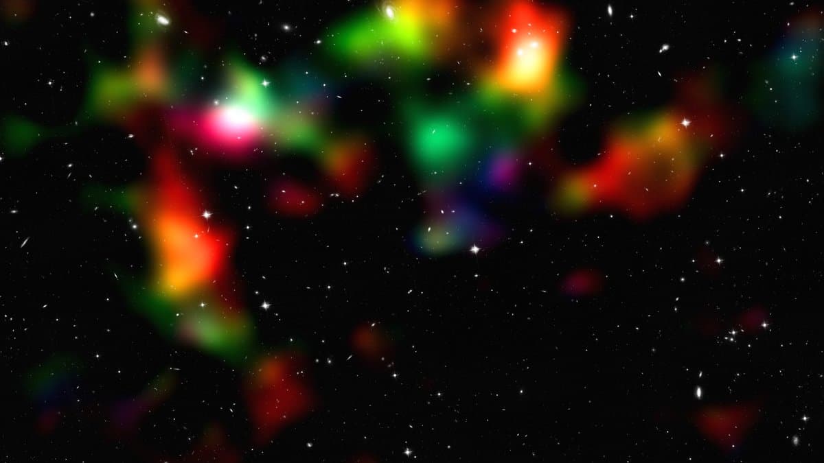 Map of the COSMOS survey field: clouds of colour marking concentrations of matter at different distances, layered over a dark sky full of faint galaxies.