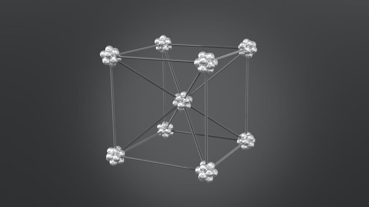 Computer-generated model of a body-centered cubic crystal lattice: clusters of silver spheres at the eight corners of a cube and one at its center, joined by metallic rods on a dark gray background.