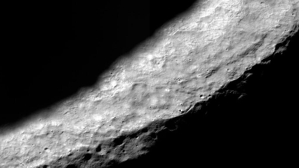 The sunlit rim of Shackleton Crater at the Moon's south pole seen from orbit, with the crater interior in deep shadow.