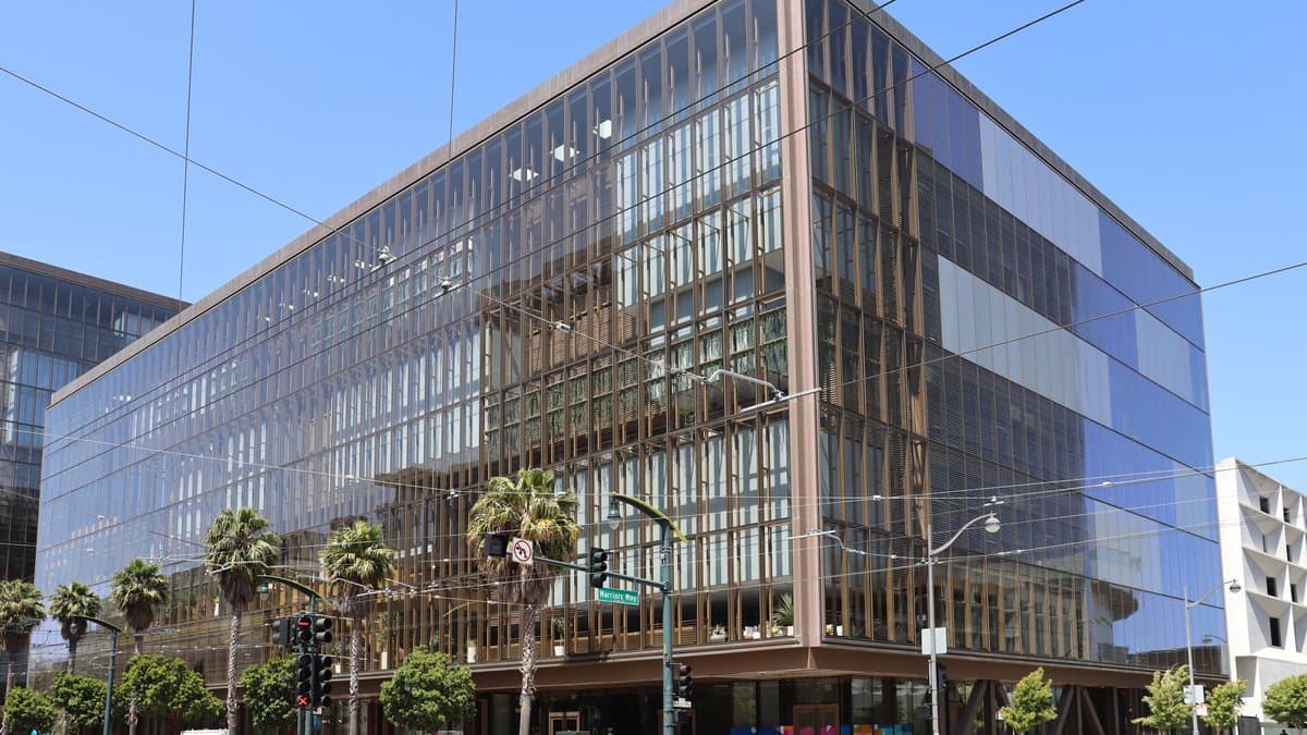 The glass-fronted office building at 1515 Third Street in San Francisco's Mission Bay district, seen from a street corner under a clear sky.