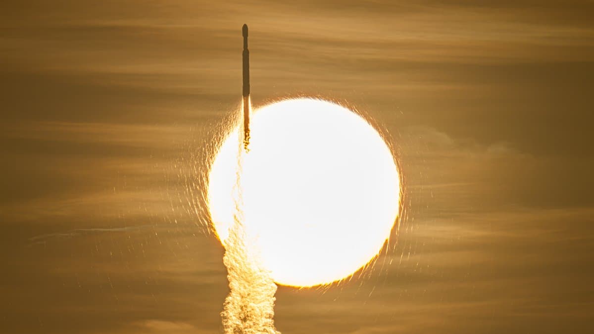 A rocket silhouetted against the Sun as it climbs through golden haze, carrying NASA Roman Space Telescope.
