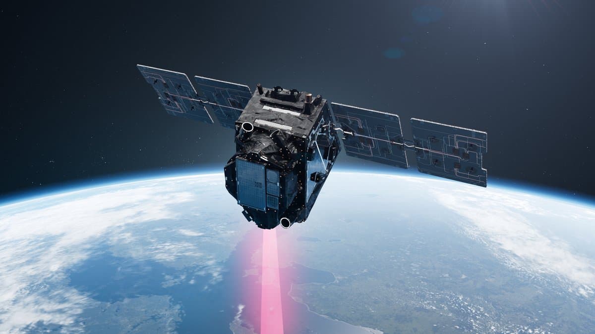 Artist's impression of the FLEX satellite in orbit above Earth, its solar panels extended and a red beam pointing down at the land below
