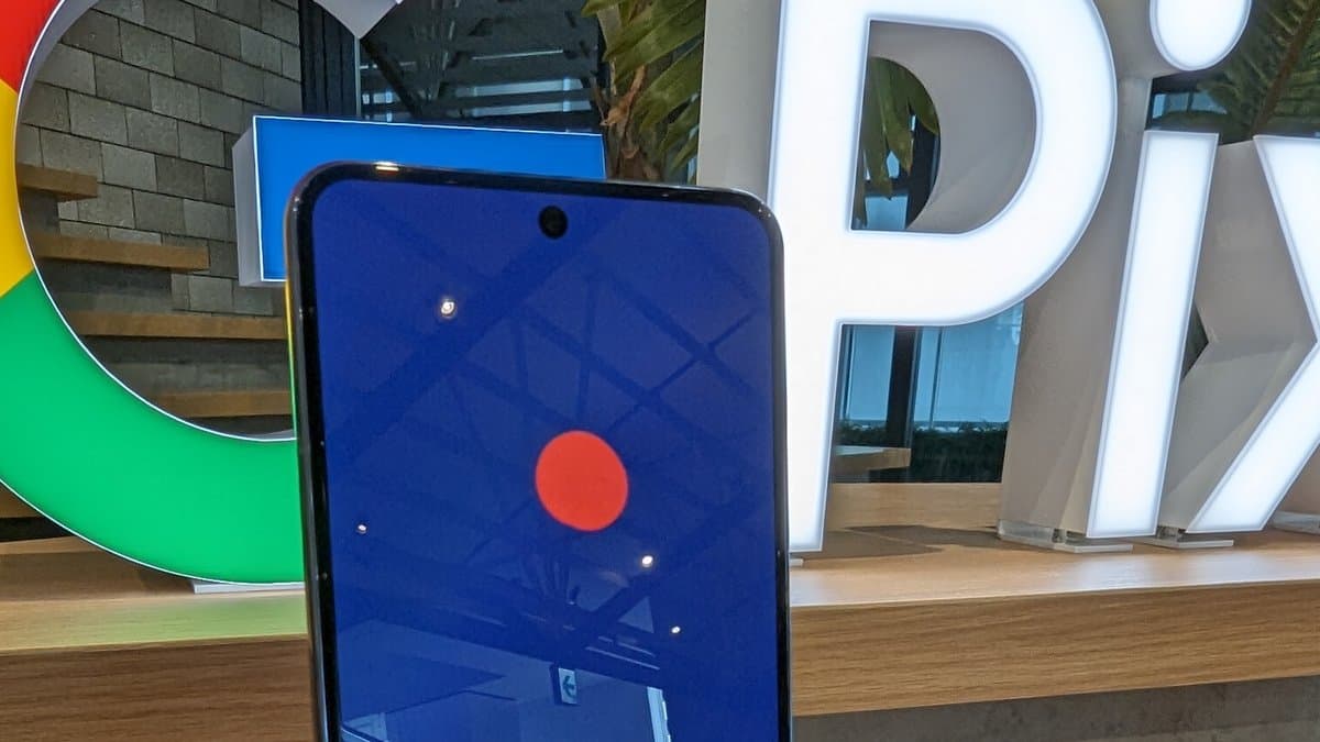 A Google Pixel 8 Pro standing upright on a display plinth in a Google store, with an illuminated Pixel sign and a Google logo behind it.