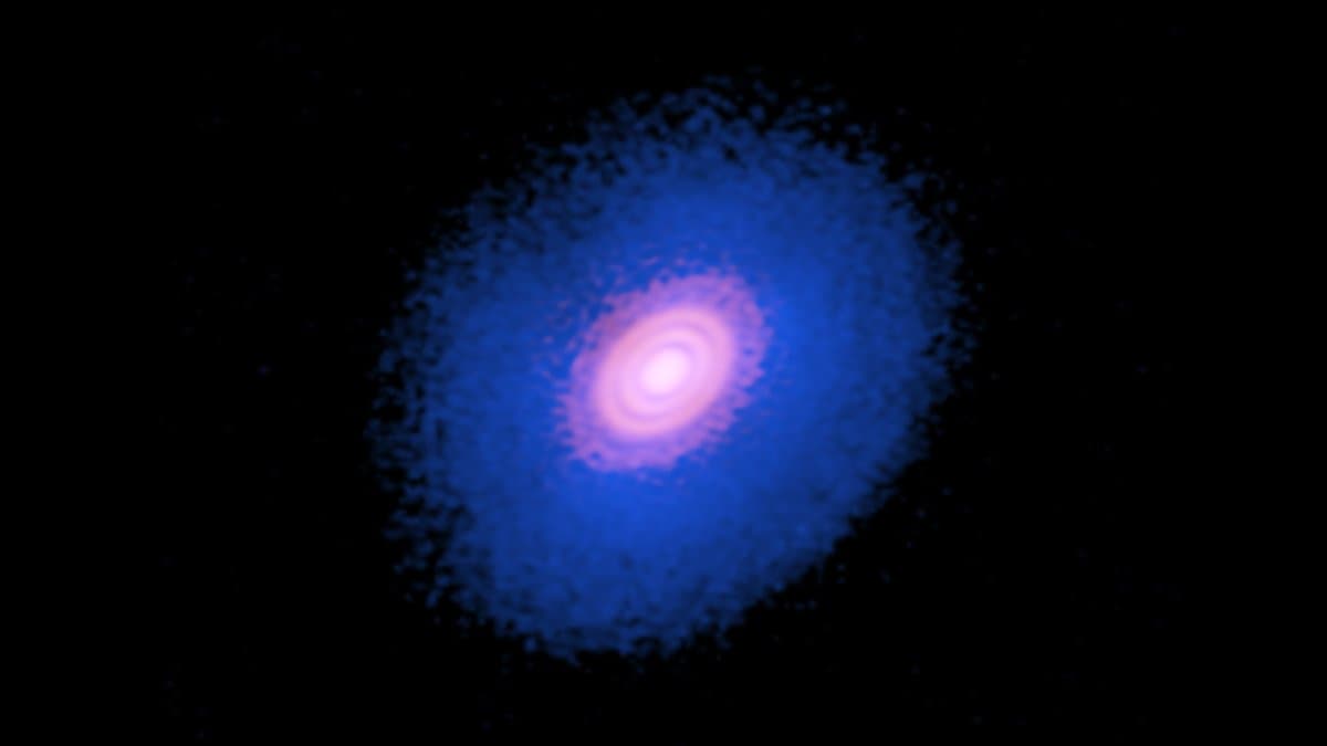 ALMA radio image of the protoplanetary disk around the young star HD 163296: a bright orange dust disk at the center, surrounded by a larger blue cloud of gas.