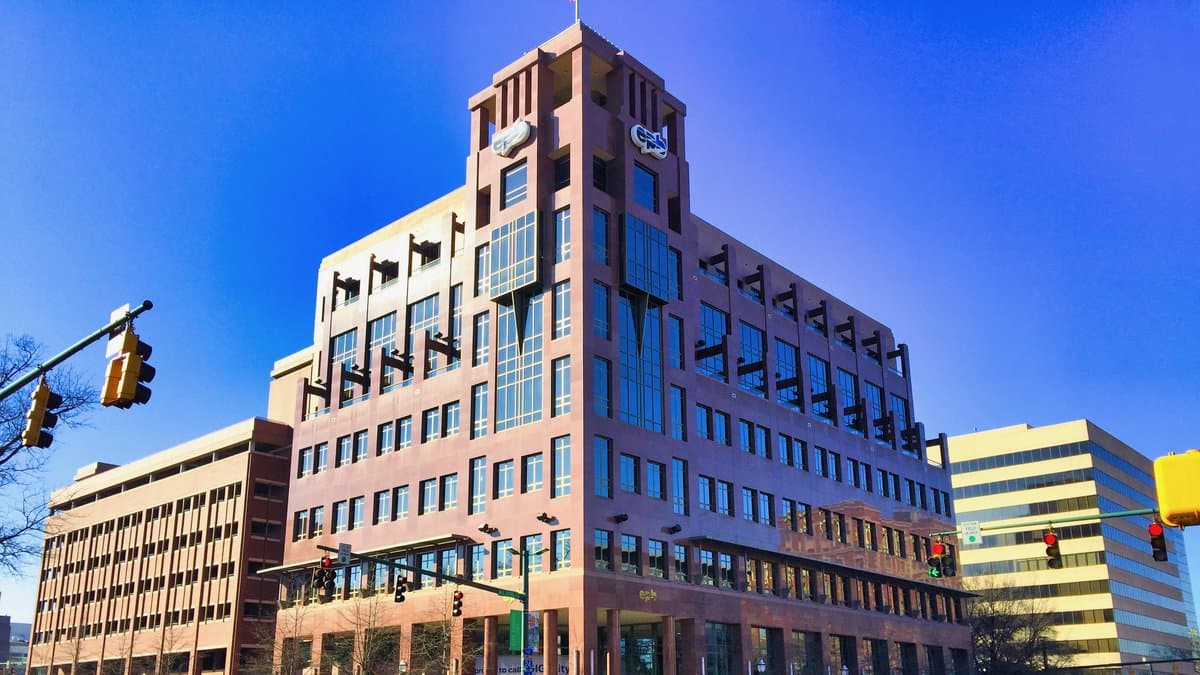 EPB's granite headquarters tower in downtown Chattanooga, with the utility's logo near the roofline, under a clear blue sky.