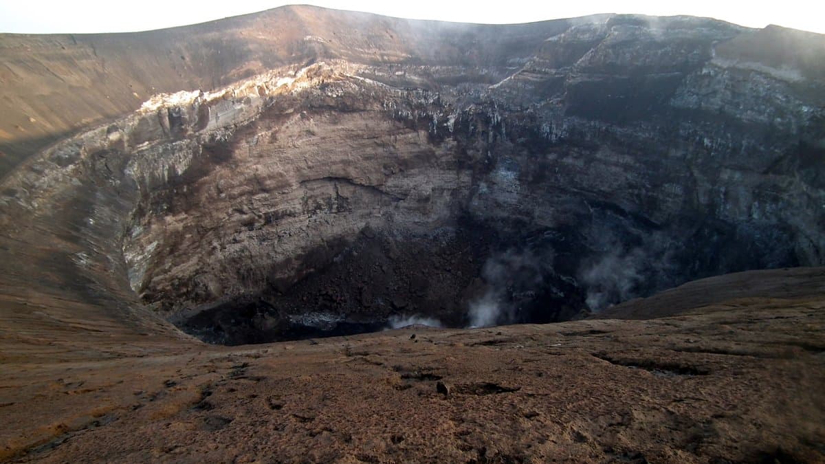 Steam drifts from the floor of a deep, steep-walled crater at the summit of Ol Doinyo Lengai in northern Tanzania.