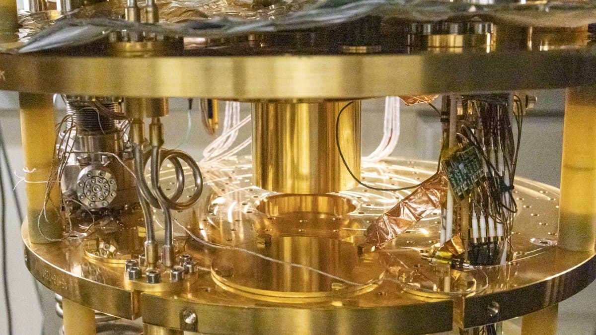 Gold-plated cold stages and coaxial microwave wiring inside an open dilution refrigerator in a quantum computing laboratory.