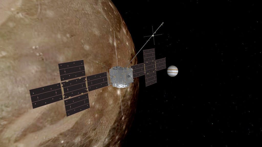 Illustration of the Juice spacecraft with its cross-shaped solar panels above the cratered surface of an icy moon, with Jupiter in the black sky beyond.