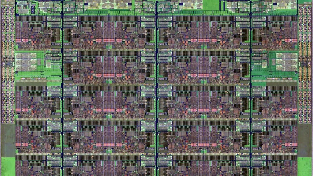 Extreme close-up photograph of the silicon die of an Intel Skylake-SP Xeon server processor, showing a regular grid of repeating circuit blocks in green and pink.
