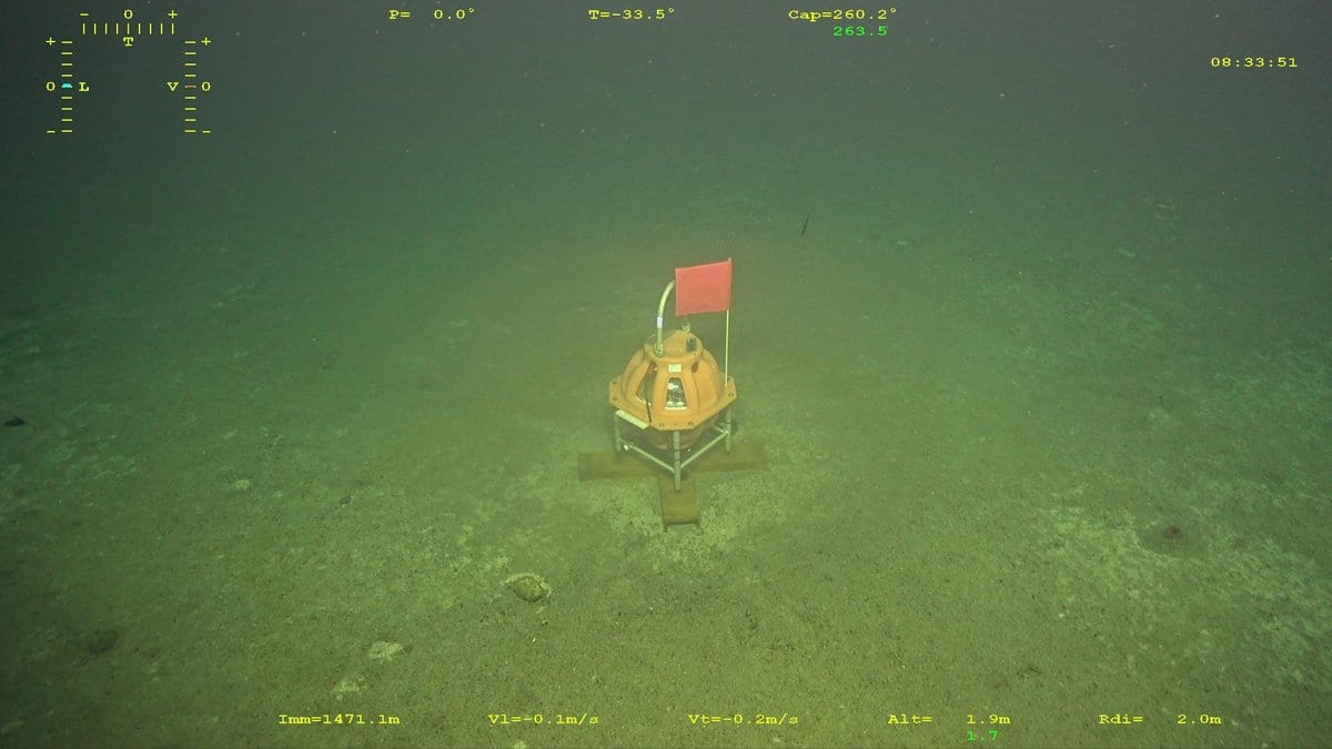 An ocean-bottom seismometer standing on a silty seabed, seen from a remotely operated vehicle