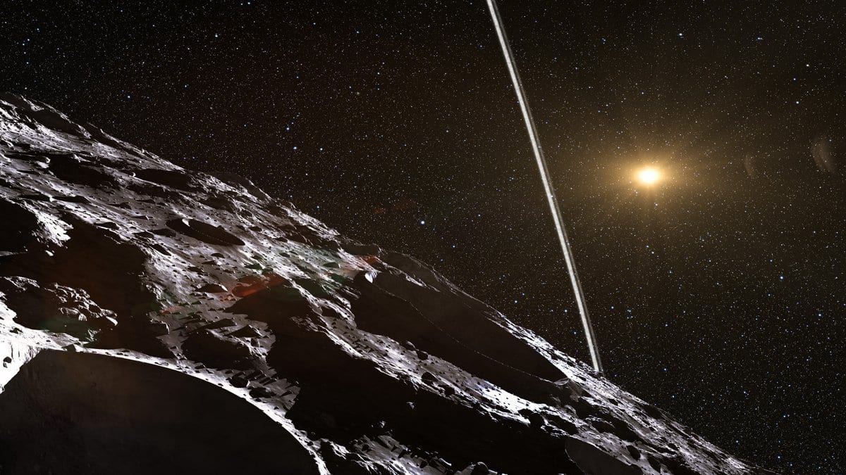 Artist's impression of the icy, cratered surface of Chariklo in the foreground, with the body's narrow rings seen almost edge on and the distant Sun shining among stars.