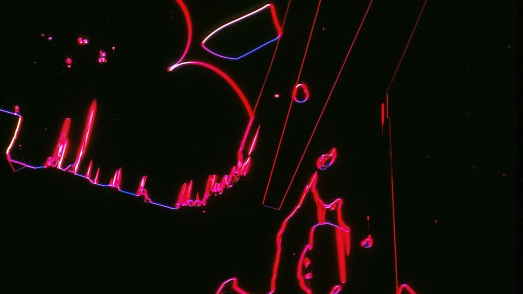 Microscope image of cisplatin crystals, their edges glowing red, pink and blue against a black background.