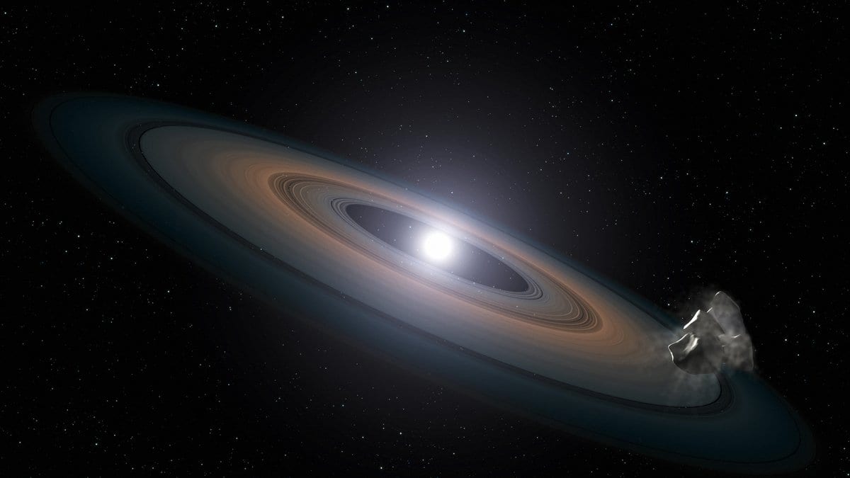 Illustration of a white dwarf star at the center of a broad, tilted ring of pulverized rock, with a fragmenting asteroid at the ring's outer edge.