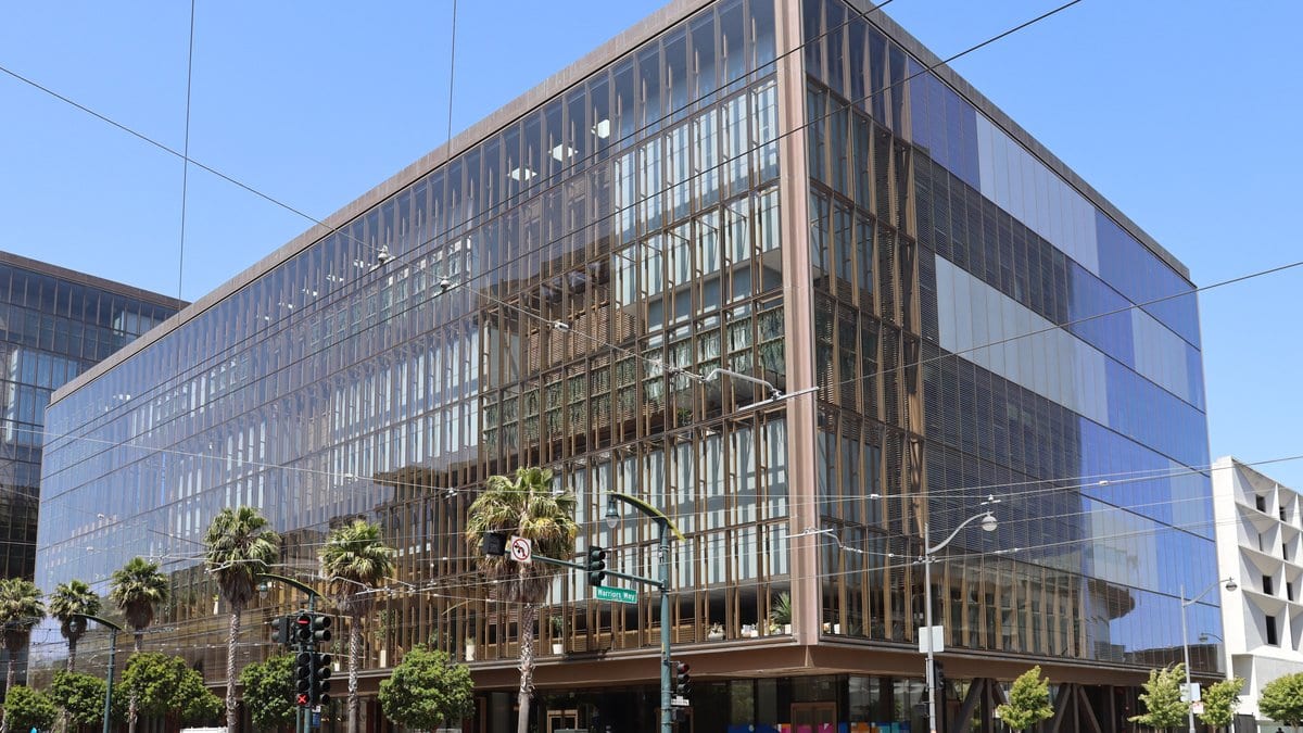 The glass-fronted office building at 1515 Third Street in San Francisco's Mission Bay district, seen from a street corner under a clear sky.