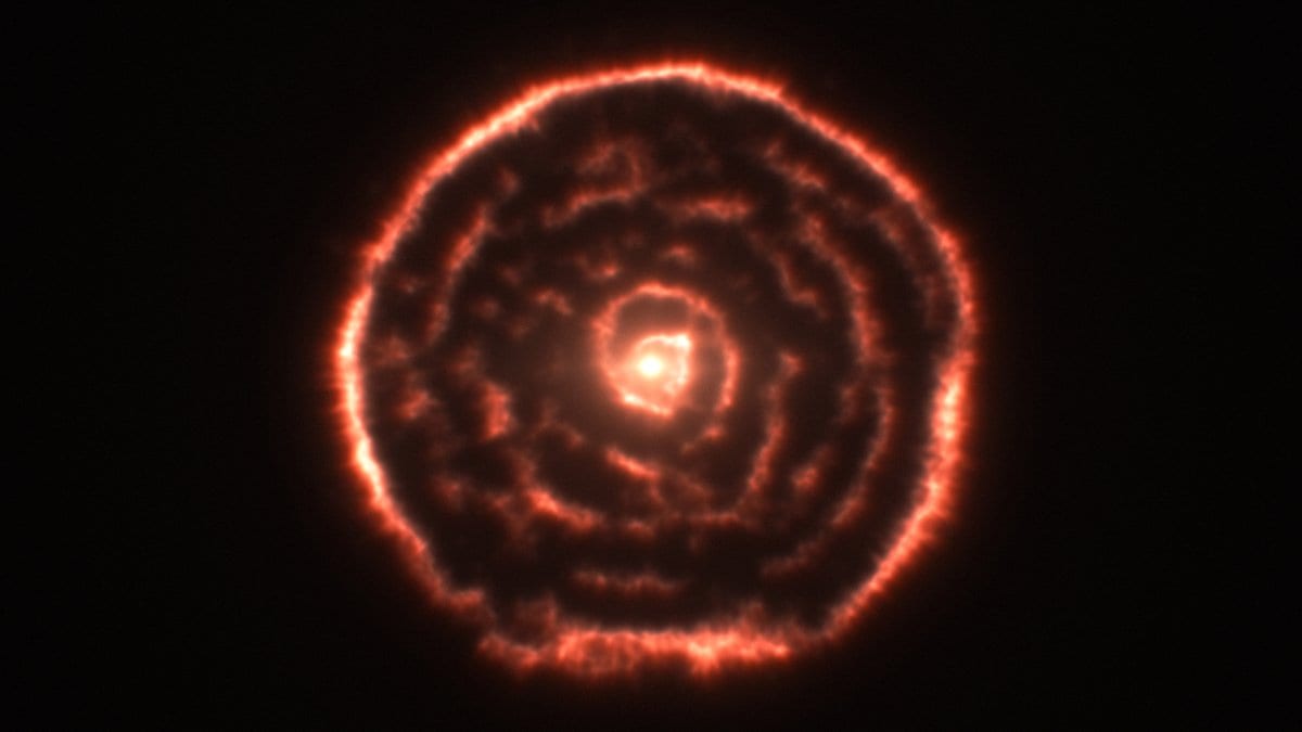 Concentric orange shells of gas surrounding a bright central star, mapped by the ALMA radio telescope array.