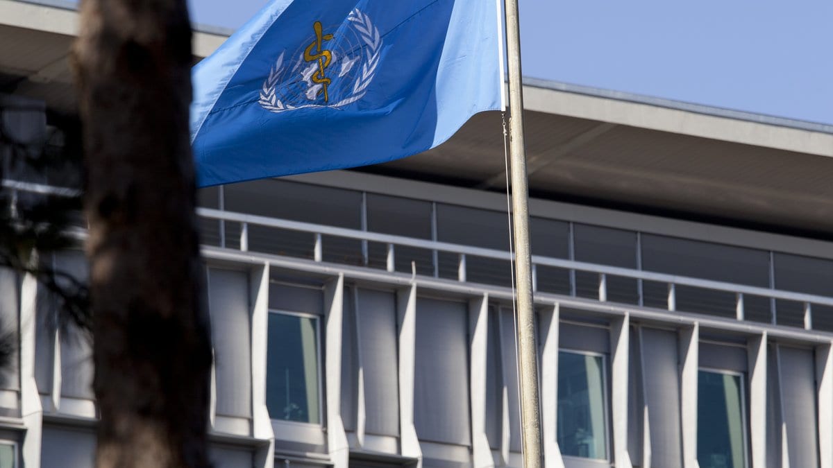 The flag of the World Health Organization flies on a pole in front of the agency's headquarters building in Geneva, Switzerland.