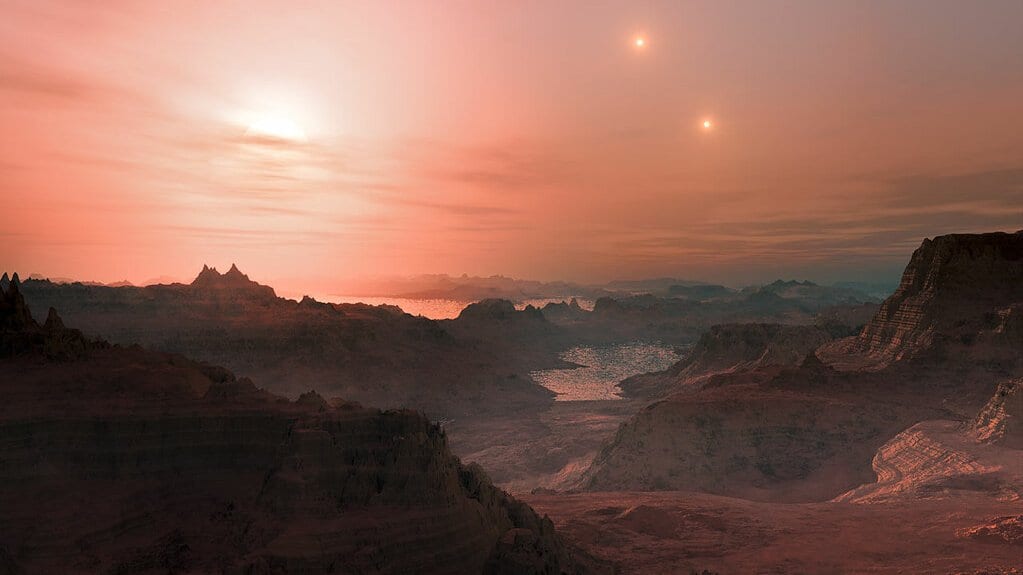 An artist's concept of a reddish rocky landscape with water pooled in the valleys, under a hazy pink sky holding a low bright sun and two smaller bright stars.