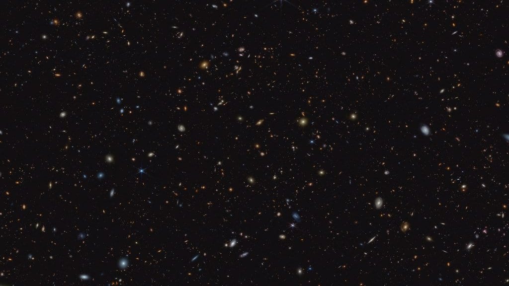 A deep near-infrared view from the James Webb Space Telescope, filled with hundreds of small, faint galaxies scattered across black sky.