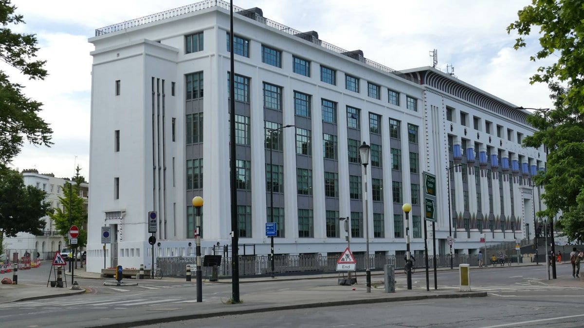 A white art deco office block with Egyptian style columns, seen from a street corner in north London.