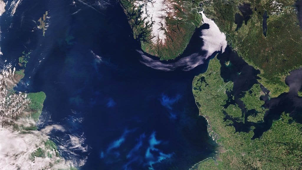 Satellite view of the North Sea, with Scotland and the Shetland Islands at left, Norway at top and the Danish coast at right, and pale blue phytoplankton swirls across the southern basin.