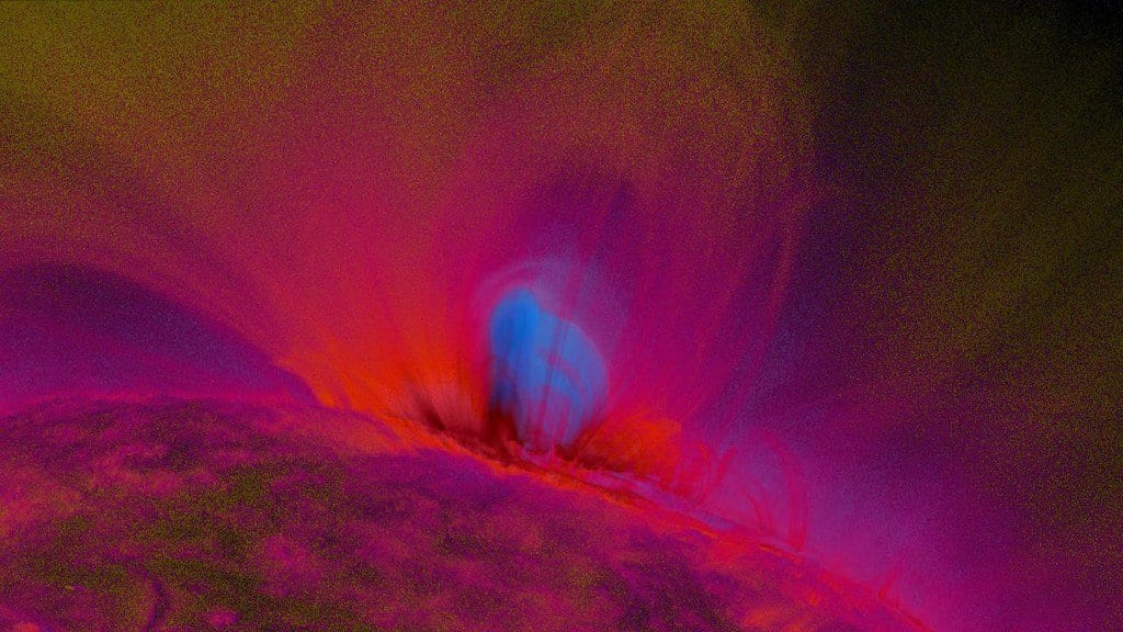 A bright, twisted loop of hot plasma rises above the edge of the Sun, imaged in extreme ultraviolet light and shown in false color.