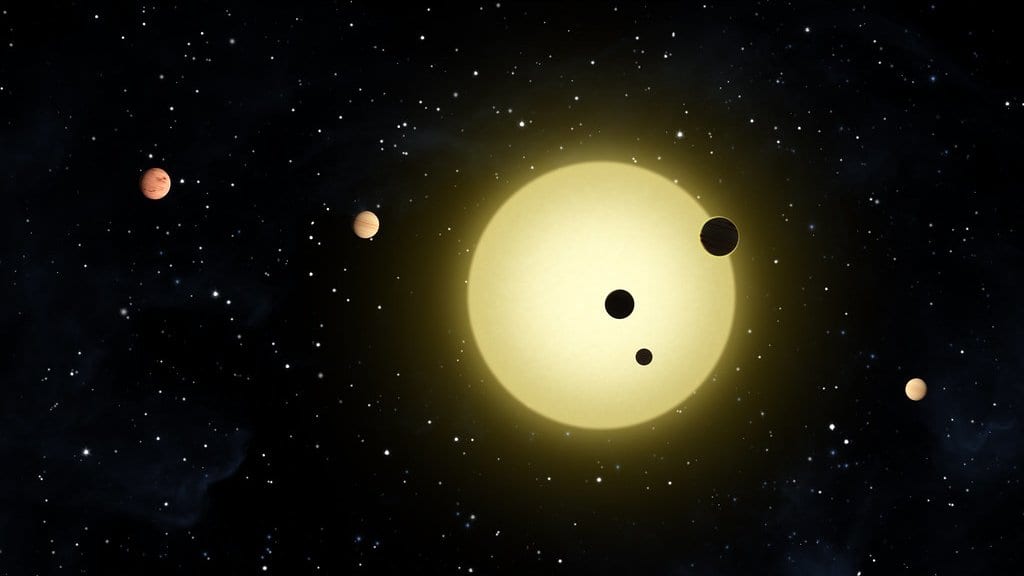 Artist's rendering of a yellow star with six similar-size planets in tightly spaced orbits, three of them crossing the star's disk.