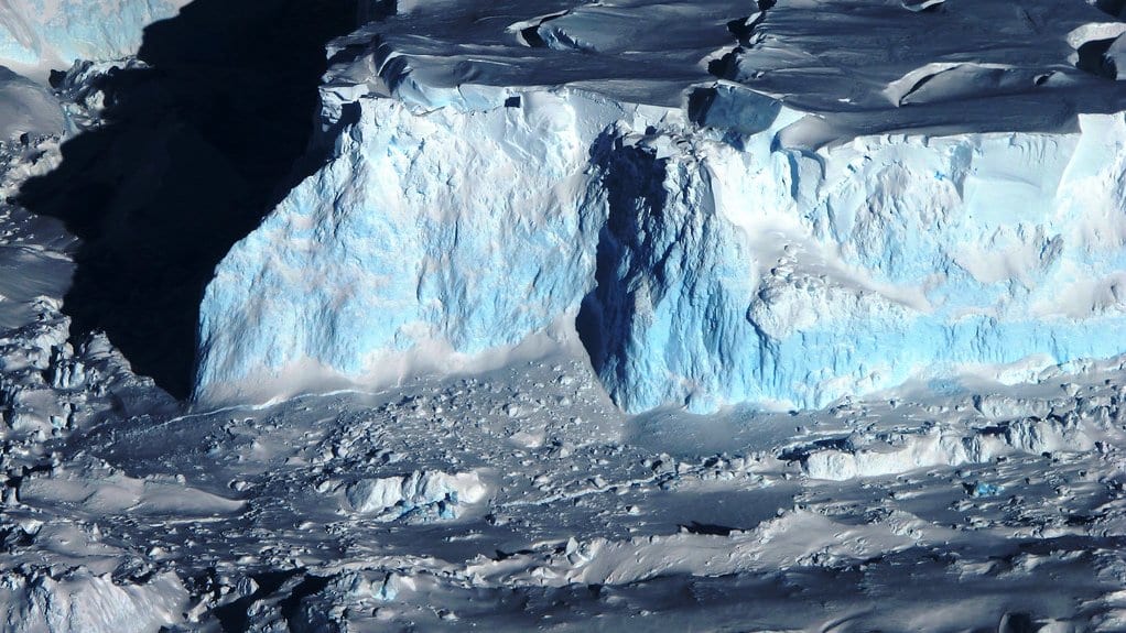 Aerial view of the ice cliff at the seaward edge of Thwaites Glacier, with broken ice below it.