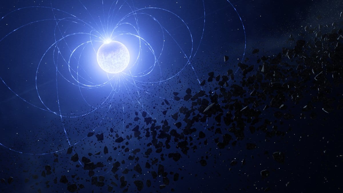 An artist's impression of the white dwarf WD 0816-310: a small brilliant blue-white star ringed by looping magnetic field lines, with a swarm of dark rocky debris streaming in toward it.