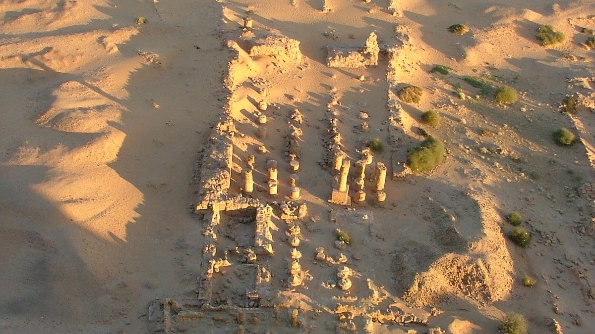 Aerial view of the ruined walls and column bases of an ancient temple in desert sand at Jebel Barkal, Napata, Sudan.