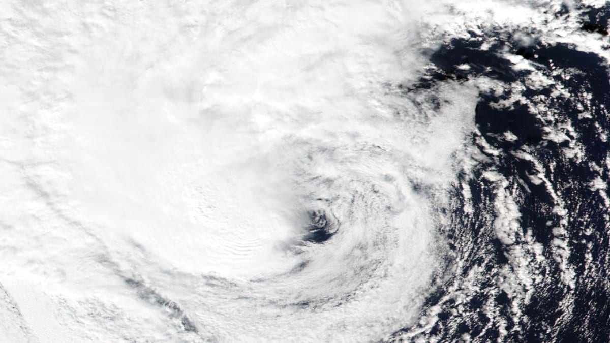 Satellite image of Subtropical Storm Josephine showing a broad cyclonic cloud band and a small clear spot near the storm's center, over open ocean
