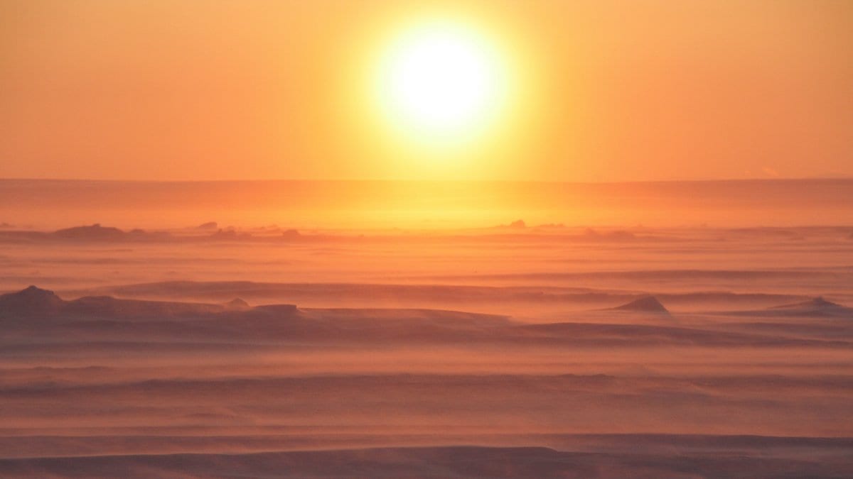 Low sun over wind-blown snow and ice covering the frozen surface of the Laptev Sea.