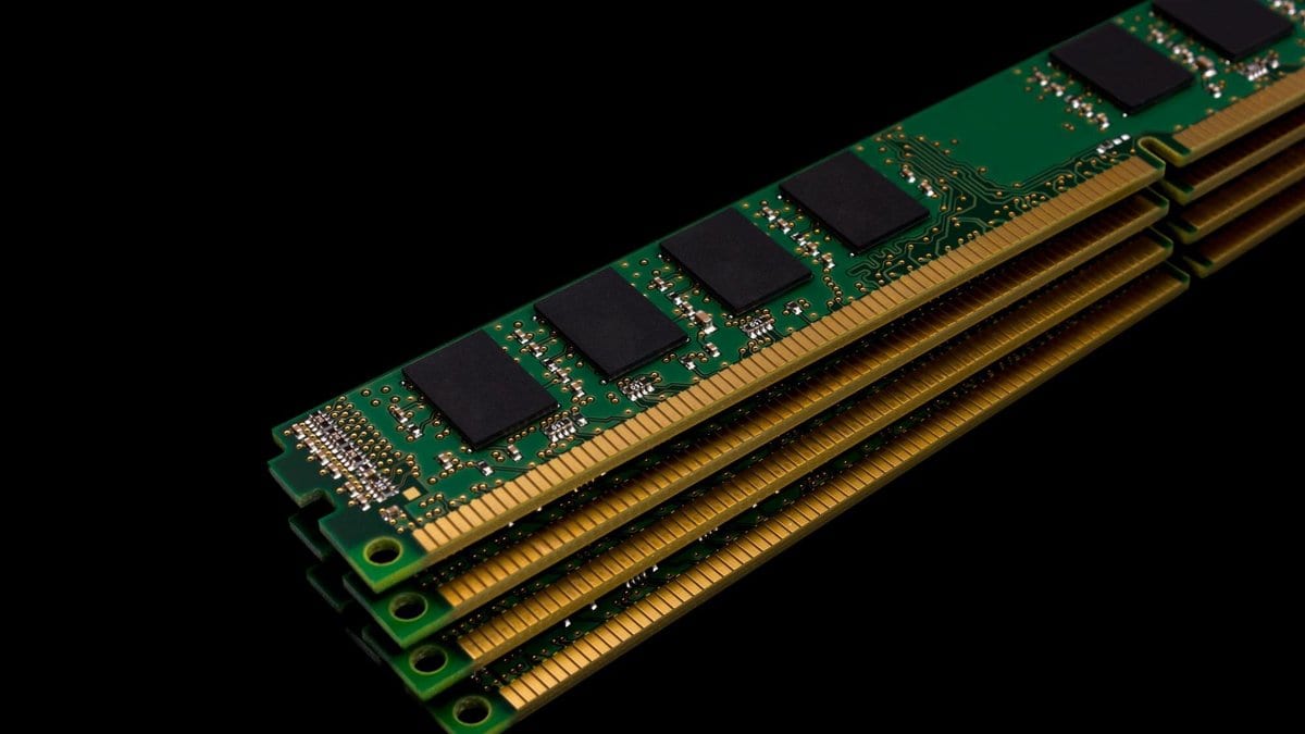 Four computer memory modules stacked at an angle against a black background.